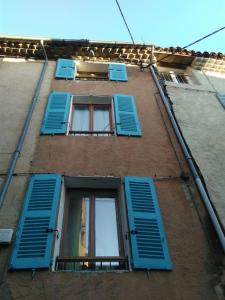 ein Gebäude mit blauen Fensterläden in der Unterkunft Coquette petite maison de village in Aups
