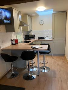 una cucina con 2 sgabelli da bar e piano di lavoro di Cosy 3-Bed Apartment on Exmoor a Minehead