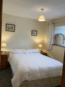 una camera da letto con un letto bianco e una finestra di Cosy 3-Bed Apartment on Exmoor a Minehead