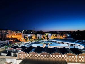 a large building with a swimming pool at night at Flor da Providência in Viseu