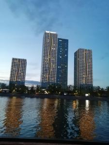 two tall buildings next to a body of water at Grand Alatau Apartment in Astana