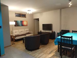 a living room with a table and chairs and a tv at Puerta Sur Apart in Malargüe