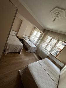 a hotel room with two beds and a window at Ecemsuit5 in Yomra