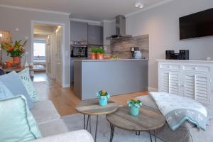 a living room with a couch and tables and a kitchen at Nordwind in Westerland