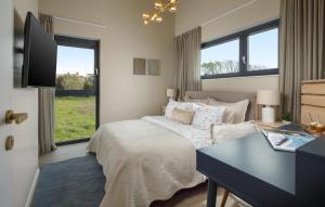 a bedroom with a bed and a desk and windows at Nice Home In Porec With Wifi in Poreč