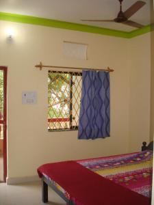 a bedroom with a bed and a window at Shree Hari Guest House in Anjuna