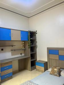 a bedroom with a bed and a desk and blue cabinets at 2 Chaaban 1, 1136 in Larache +8 photos