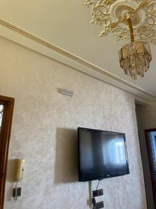 a flat screen tv on a wall with a chandelier at 2 Chaaban 1, 1136 in Larache