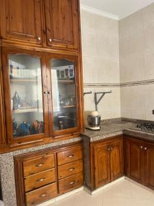 a kitchen with wooden cabinets and a counter at 2 Chaaban 1, 1136 in Larache