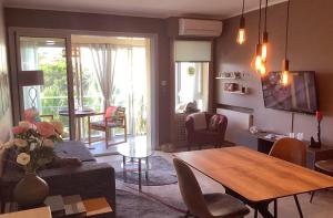 a living room with a table and a dining room at Appartement Mimosa Croisette in Cannes