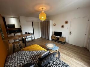 a bedroom with a bed and a table and a television at Le Petit phucket - centre ville - wifi in Niort