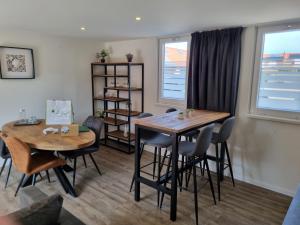 a dining room with two tables and chairs and a window at 2B nieuwe vakantie woning met terras in Westkapelle