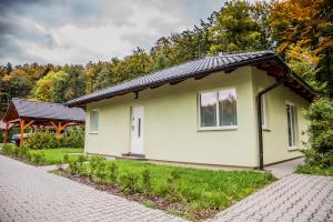 ein kleines gelbes Haus mit einer Backsteinstraße in der Unterkunft Apartmán Zlatonka in Ostravice