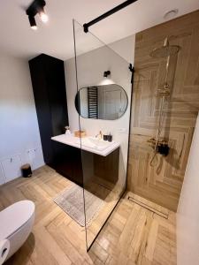 Un baño con ducha, lavabo e inodoro. en Osada Jeziernik - dom nad jeziorem z balią, en Przybrda