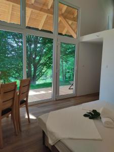 a room with a table and chairs and windows at Glamping Kr'Bee in Mala Nedelja