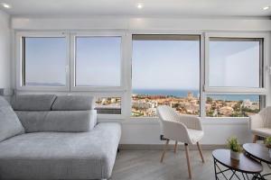 salon z kanapą i czterema oknami w obiekcie Vistas al Mar Torremolinos w mieście Torremolinos