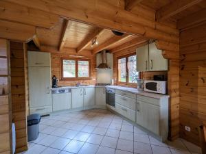 a large kitchen with wooden walls and wooden ceilings at Chalet chaleureux avec terrasse, proche forêt et sentier, à 15 km des stations de ski de Gérardmer - FR-1-589-247 in Vagney