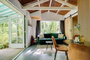 a living room with a green couch and a table at Boshuisje Felua in Nunspeet