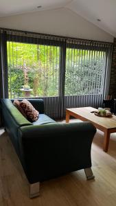 a living room with a couch and a table at Dreamwoodz - een droomchalet op de Veluwe in Laag-Soeren