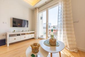 een woonkamer met een tafel en een groot raam bij Central but quiet, pool and WIFI - fibre in Tarifa