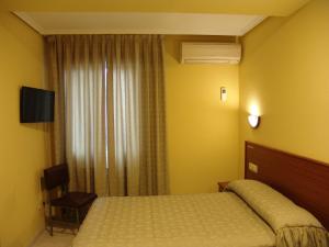 Habitación de hotel con cama y ventana en Hostal Athlanta, en Villalpando