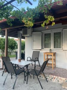 a patio with a table and chairs under a pergola at Beverly house in Kriopigi