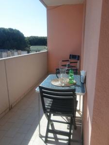 a small table and chairs on a balcony at Comfy flat with terrace by the pool in Rosolina Mare