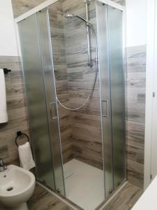a shower with a glass door in a bathroom at Comfy flat with terrace by the pool in Rosolina Mare