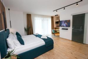 a bedroom with a large bed and a living room at Várvavár Apartman Gyula in Gyula