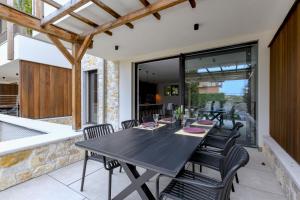 a black dining table and chairs on a patio at MGH Luxury - Corte Garden Bardolino 34 in Bardolino