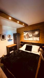 sypialnia z dużym łóżkiem i drewnianą ścianą w obiekcie Can Sansa Appartement 4* jacuzzi maison pyrénéenne w mieście Font-Romeu-Odeillo-Via