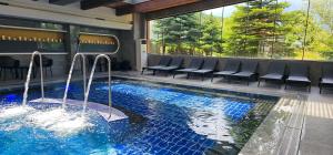 a swimming pool in a building with chairs around it at Apartmanica Double room apartment with balcony 101-30 St Ivan Rilski SPA Resort Bansko in Bansko