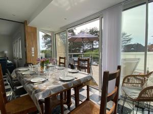 a dining room with a table with plates and glasses at La musique des Vacances in Portbail