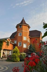 a large orange building with a tower at Villa Victoria in Łeba