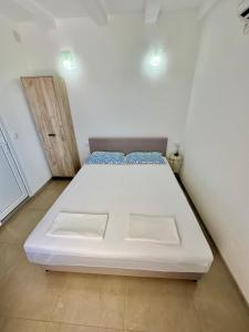 a small bedroom with a white bed in a room at Montenegrina Apartment in Budva