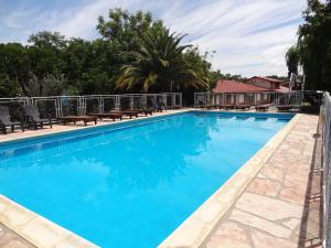 a large blue swimming pool with chairs and trees at Hostería Lida in Merlo