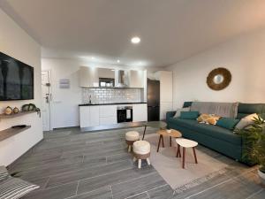 een woonkamer met een groene bank en een keuken bij Playa Paraiso Apartment in Adeje