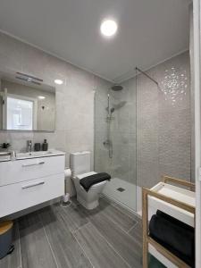 een badkamer met een douche, een toilet en een wastafel bij Playa Paraiso Apartment in Adeje