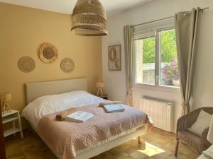 ein Schlafzimmer mit einem Bett, einem Fenster und einem Stuhl in der Unterkunft Magnifique Villa typique du Sud avec Piscine privée et jardin méditerranéen in Saint-Vincent-de-Barbeyrargues + 40 Fotos