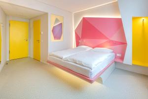 a bedroom with a bed with a colorful wall at Prize by Radisson, Münster City in Münster