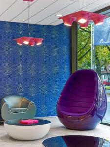 a purple chair and a bowl on a table at Prize by Radisson, Hannover City in Hannover