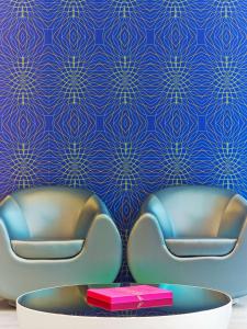 two chairs in a room with a blue wall at Prize by Radisson, Hannover City in Hannover