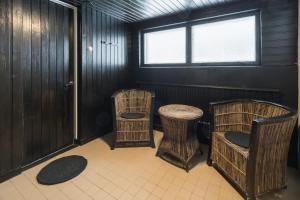 a room with wicker chairs and a table and a window at BohoSauna in Oulu