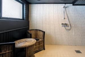 a shower with a table and a chair in a room at BohoSauna in Oulu