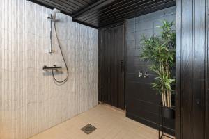 a bathroom with a shower with a plant in it at BohoSauna in Oulu +5 photos