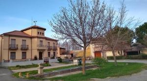 a building with a tree in front of it at Casa rural ‘’La Nuestra’’ in Bercimuel