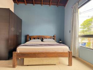 a bedroom with a wooden bed and a window at Apartamento Relax in Medellín