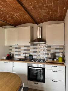 a kitchen with white cabinets and a stove top oven at Vinicio's House in Carmignano