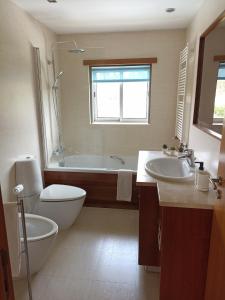 un bagno con vasca, WC e lavandino di Casa do Sol - Entre o Mar e o Pinhal ad Apúlia Altre 37 foto