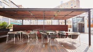 a patio with tables and chairs on a deck at TOC Hostel Barcelona in Barcelona